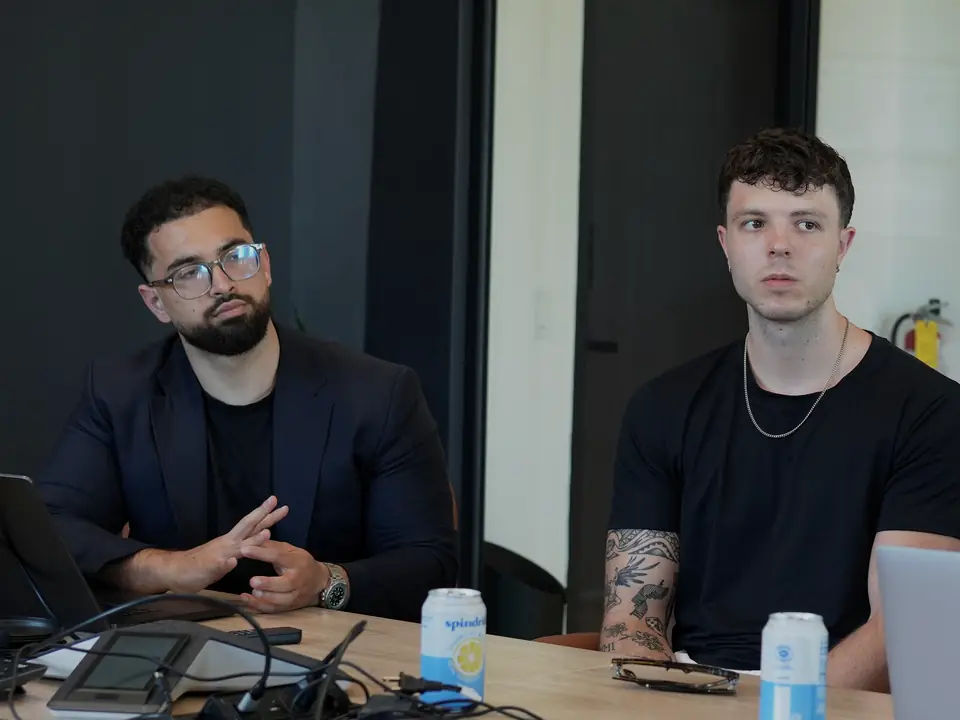 Two of the team listening at a boardroom table during a client session in Miami.